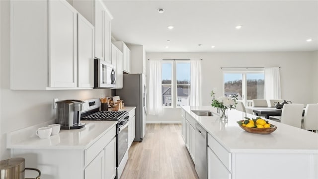 211 Truth Cir, Jackson Twp, PA 16037 - kitchen with stainless steel appliances, light wood-style floors, a kitchen island with sink, white cabinetry, and recessed lighting