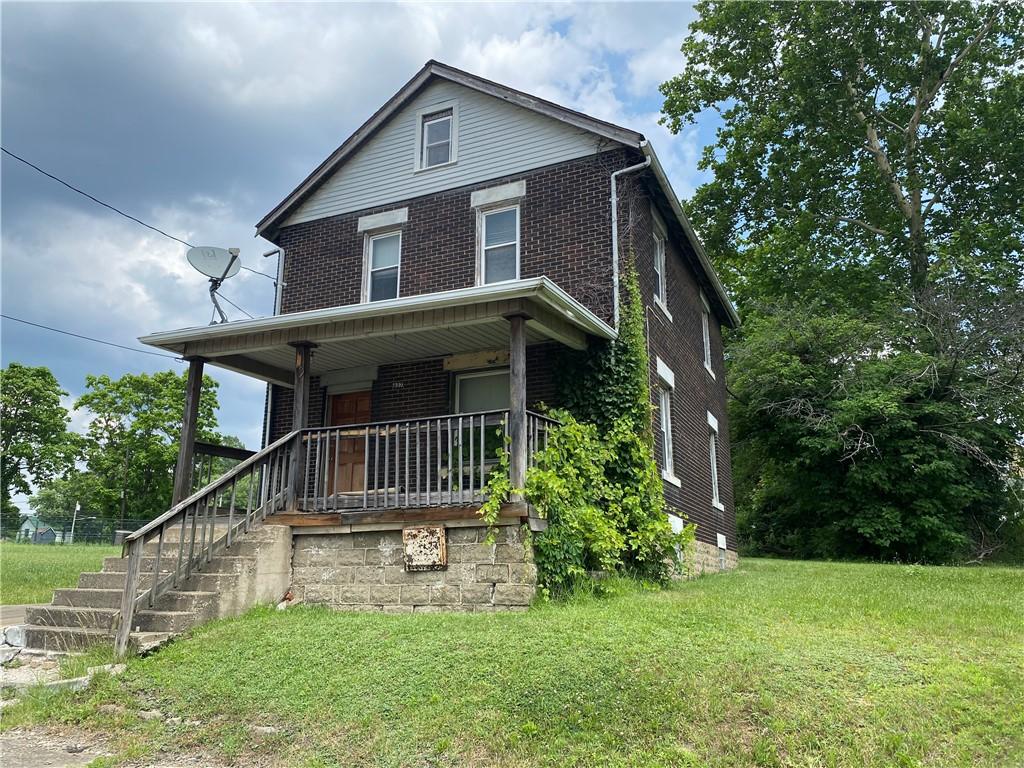 807 Lee Ave, Farrell, PA 16121 - american foursquare style home with brick siding, covered porch, a front yard, and stairway
