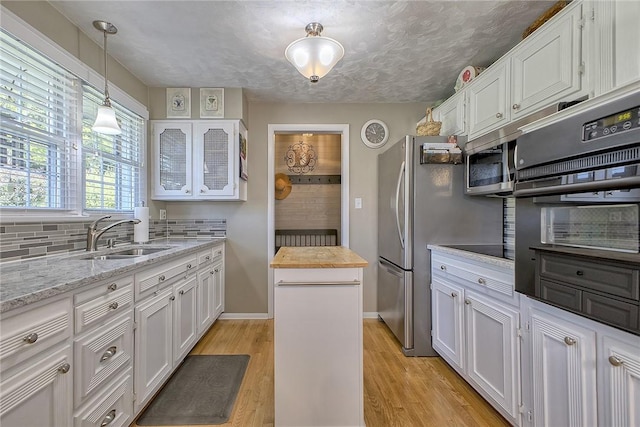 2 Redgrave Dr, Hempfield Twp, PA 15601 - kitchen featuring white cabinetry, black appliances, light wood-style flooring, glass insert cabinets, and pendant lighting