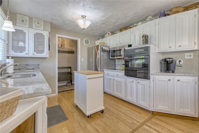 2 Redgrave Dr, Hempfield Twp, PA 15601 - kitchen featuring stainless steel appliances, white cabinets, light wood-type flooring, and hanging light fixtures
