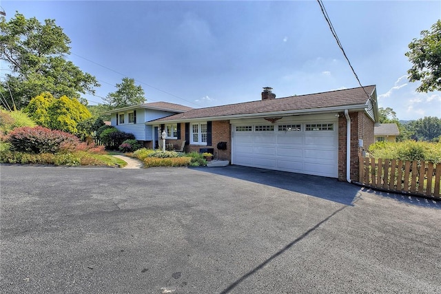 2 Redgrave Dr, Hempfield Twp, PA 15601 - tri-level home with brick siding, a chimney, driveway, and a garage