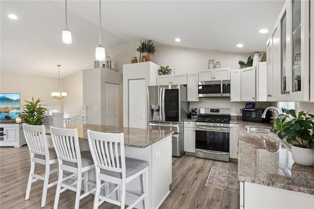 196 Weathervane Dr, Slippery Rock Twp, PA 16057 - kitchen with stainless steel appliances, lofted ceiling, light wood finished floors, a center island, and glass insert cabinets