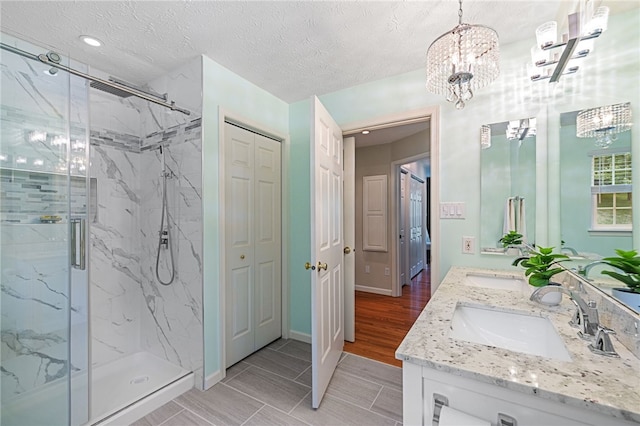 113 Great Rock Dr, Bethel Park, PA 15102 - full bath with double vanity, a marble finish shower, a chandelier, a textured ceiling, and a closet