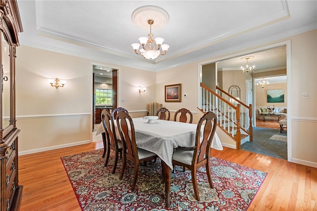 113 Great Rock Dr, Bethel Park, PA 15102 - dining area with a chandelier, a raised ceiling, light wood-style flooring, and crown molding
