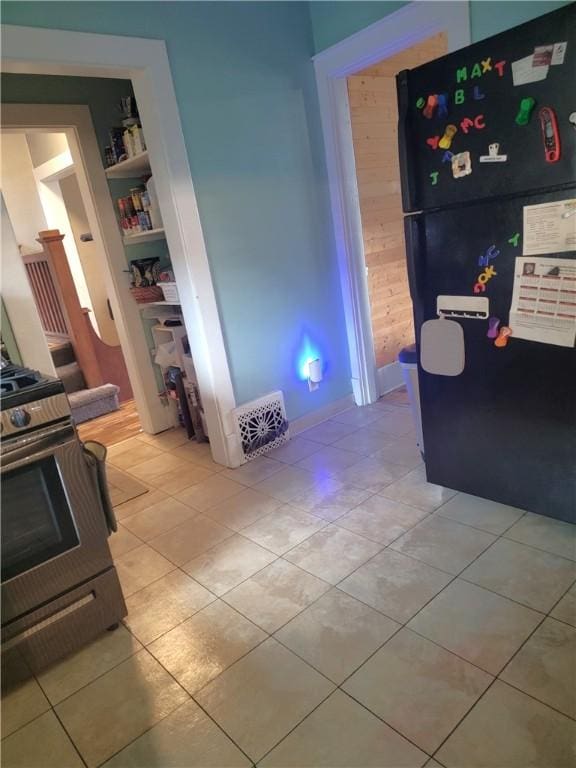 413 River Ave, Aliquippa, PA 15001 - kitchen with freestanding refrigerator, range, built in shelves, and light tile patterned floors