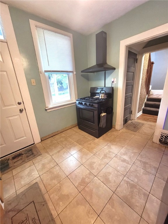 413 River Ave, Aliquippa, PA 15001 - kitchen with black gas range, wall chimney exhaust hood, and light tile patterned floors