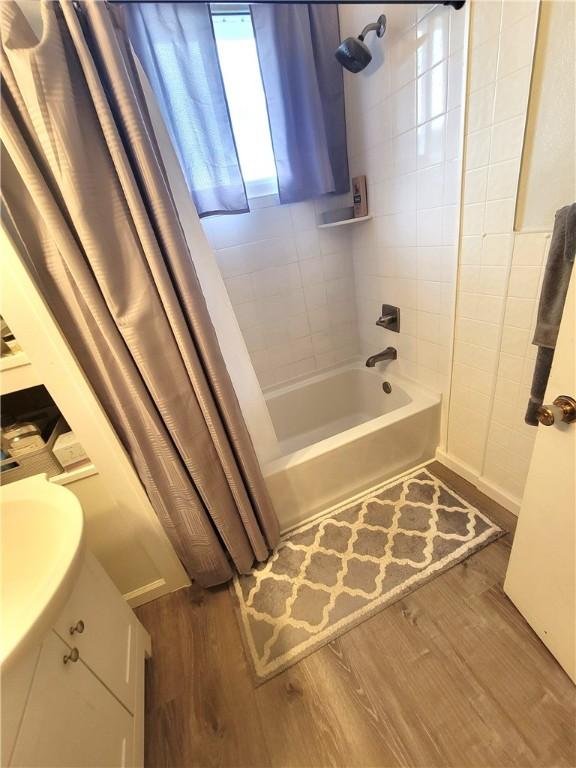 413 River Ave, Aliquippa, PA 15001 - bathroom featuring shower / tub combo with curtain, wood finished floors, and vanity