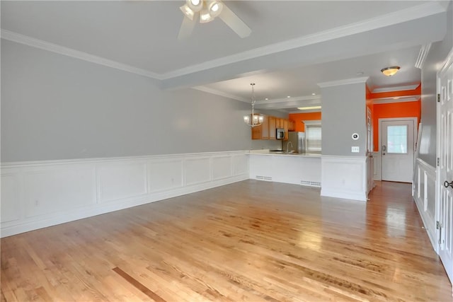 184 Wynne St, Shaler, PA 15209 - unfurnished living room with light wood-style flooring, a decorative wall, crown molding, wainscoting, and a ceiling fan