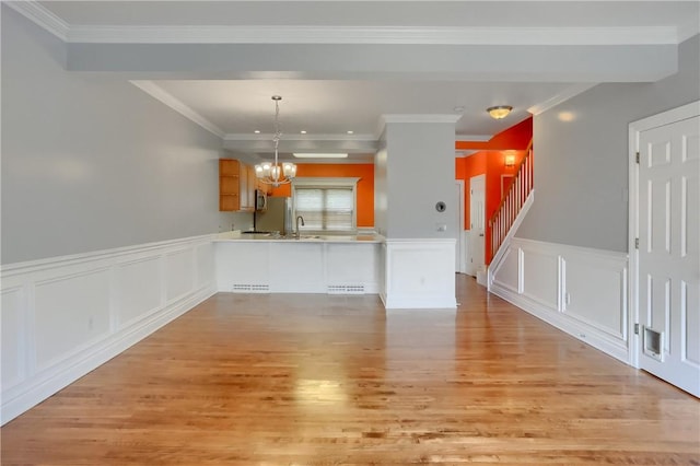 184 Wynne St, Shaler, PA 15209 - kitchen featuring a peninsula, light wood finished floors, stainless steel microwave, a chandelier, and light countertops