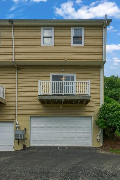 184 Wynne St, Shaler, PA 15209 - rear view of property featuring a garage, a balcony, and driveway