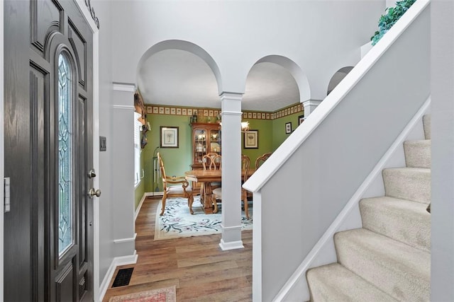 53 Peters Rd, Hempfield Twp, PA 15601 - entrance foyer with decorative columns, light wood finished floors, stairway, and plenty of natural light