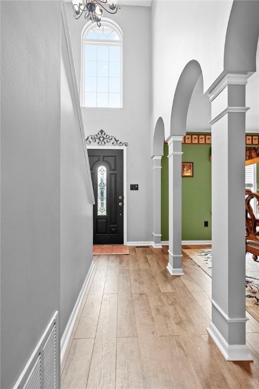 53 Peters Rd, Hempfield Twp, PA 15601 - foyer with decorative columns, a towering ceiling, arched walkways, plenty of natural light, and light wood-style flooring