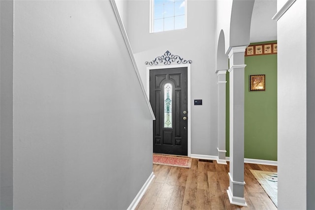 53 Peters Rd, Hempfield Twp, PA 15601 - foyer featuring decorative columns, arched walkways, wood finished floors, and a high ceiling