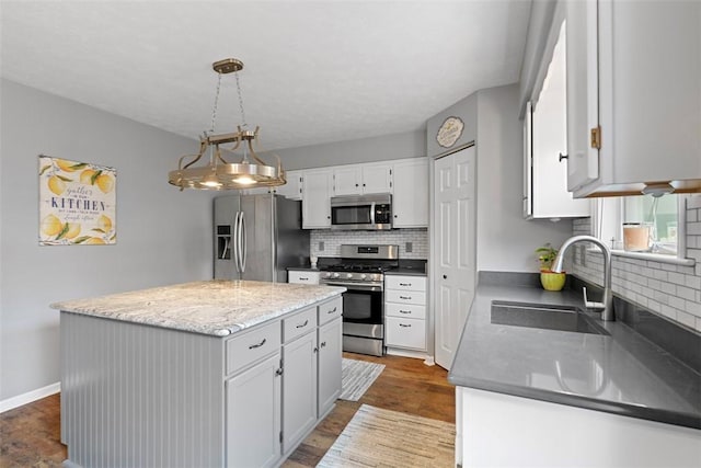 53 Peters Rd, Hempfield Twp, PA 15601 - kitchen featuring stainless steel appliances, decorative backsplash, a kitchen island, white cabinetry, and decorative light fixtures