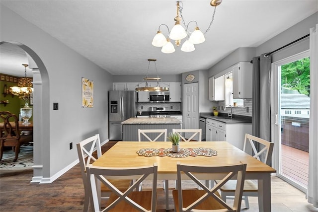 53 Peters Rd, Hempfield Twp, PA 15601 - dining space with a chandelier, arched walkways, and wood finished floors