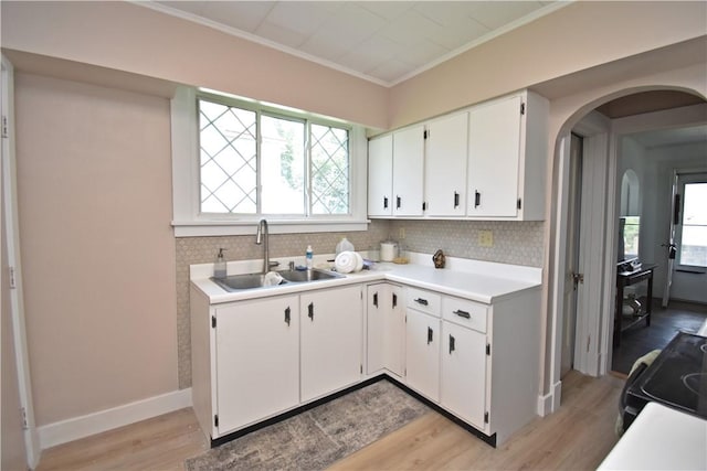 1804 Ridge Ave, Coraopolis, PA 15108 - kitchen featuring arched walkways, light countertops, black range with electric cooktop, light wood-style flooring, and crown molding