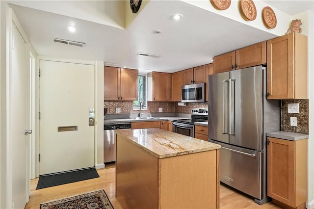 38 Foster Sq, Central North Side, PA 15212 - kitchen with stainless steel appliances, light wood-style floors, a kitchen island, backsplash, and recessed lighting