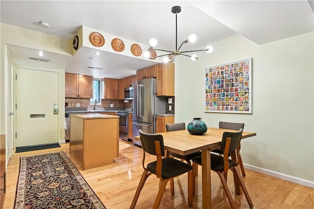 38 Foster Sq, Central North Side, PA 15212 - dining space featuring light wood-type flooring and a chandelier