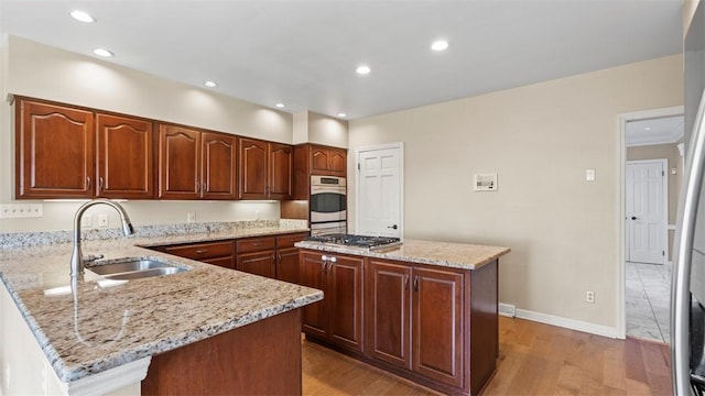 108 Trenton Cir, Peters Twp, PA 15317 - kitchen with appliances with stainless steel finishes, a peninsula, light wood finished floors, light stone countertops, and recessed lighting
