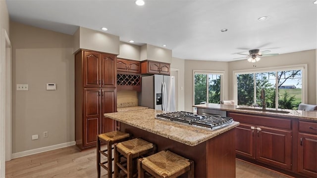 108 Trenton Cir, Peters Twp, PA 15317 - kitchen with stainless steel appliances, a center island, light wood finished floors, a breakfast bar, and light stone counters