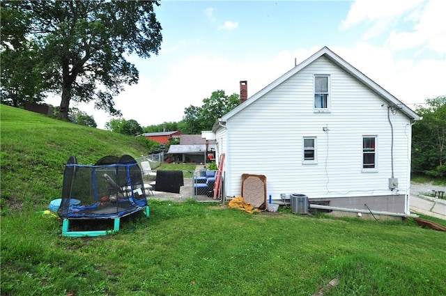 8263 Mentor Rd, Forward Twp, PA 15037 - rear view of property featuring a trampoline, a yard, and a chimney