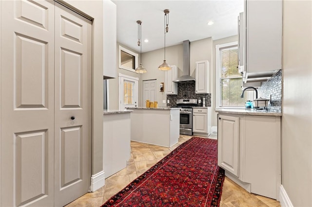 423 Lockhart St, East Allegheny, PA 15212 - kitchen with wall chimney range hood, stainless steel gas range, tasteful backsplash, white cabinetry, and recessed lighting