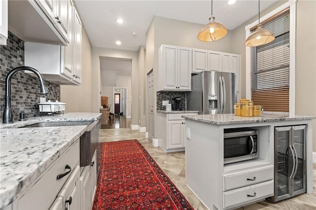 423 Lockhart St, East Allegheny, PA 15212 - kitchen with appliances with stainless steel finishes, beverage cooler, decorative backsplash, white cabinets, and light stone counters