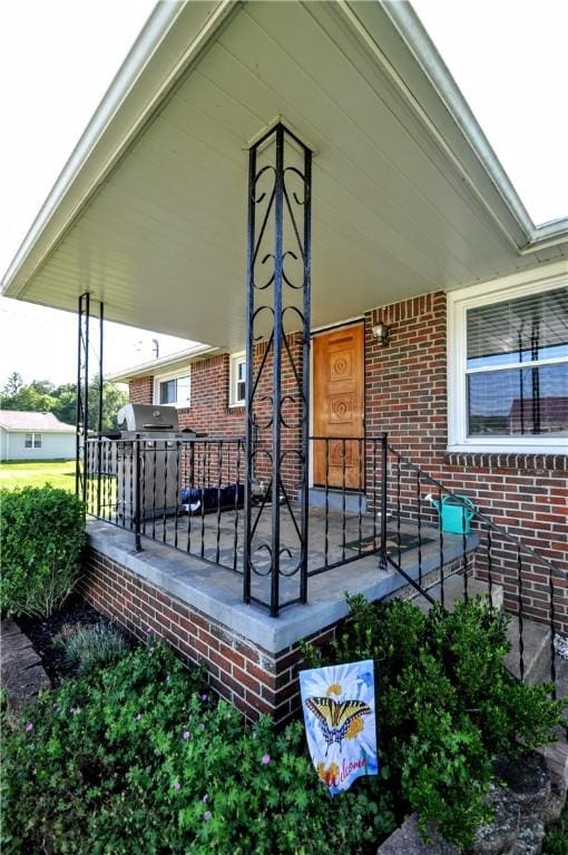 111 Wood St, Rostraver, PA 15089 - doorway to property featuring a porch and brick siding