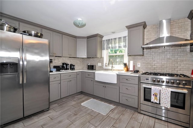 111 Wood St, Rostraver, PA 15089 - kitchen with appliances with stainless steel finishes, gray cabinets, wall chimney range hood, and backsplash