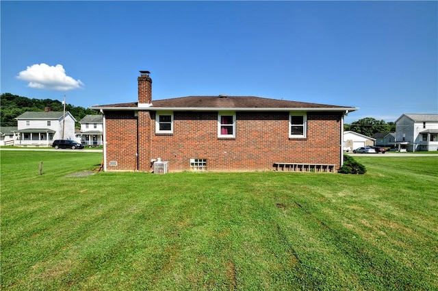 111 Wood St, Rostraver, PA 15089 - back of property featuring a chimney, a lawn, and brick siding