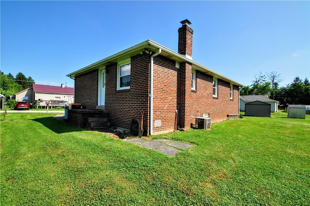 111 Wood St, Rostraver, PA 15089 - view of side of property with a chimney, brick siding, a yard, and a shed