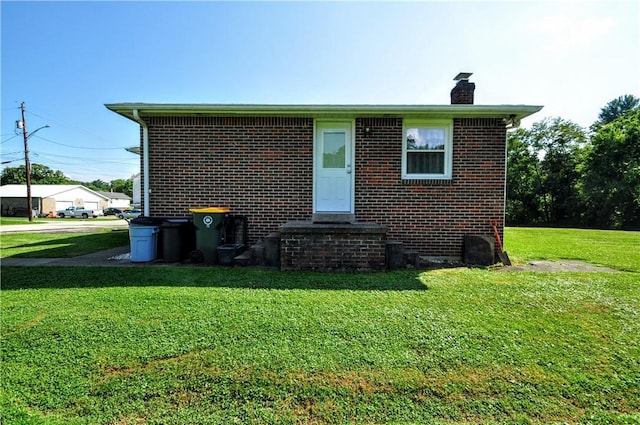 111 Wood St, Rostraver, PA 15089 - rear view of house featuring a chimney, a yard, and brick siding