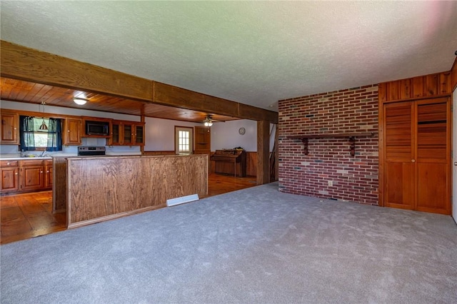 109 New Orchard Dr, Frazer, PA 15084 - unfurnished living room featuring a textured ceiling, wooden walls, ceiling fan, carpet flooring, and brick wall