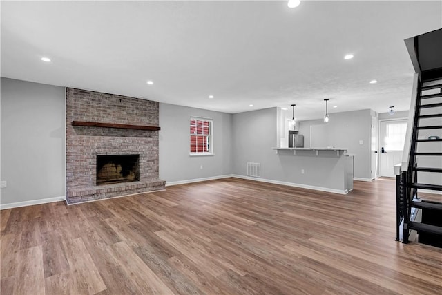 613 Newton Sq, Moon/Crescent Twp, PA 15108 - unfurnished living room with recessed lighting, wood finished floors, and a brick fireplace