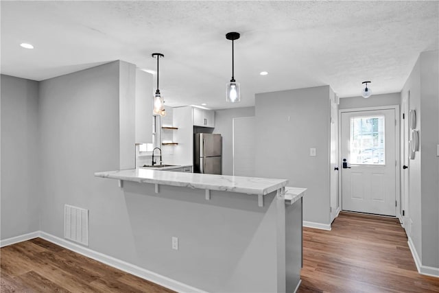 613 Newton Sq, Moon/Crescent Twp, PA 15108 - kitchen with freestanding refrigerator, a peninsula, white cabinetry, dark wood-style flooring, and recessed lighting