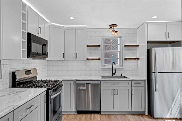 613 Newton Sq, Moon/Crescent Twp, PA 15108 - kitchen with open shelves, stainless steel appliances, gray cabinets, tasteful backsplash, and light stone countertops