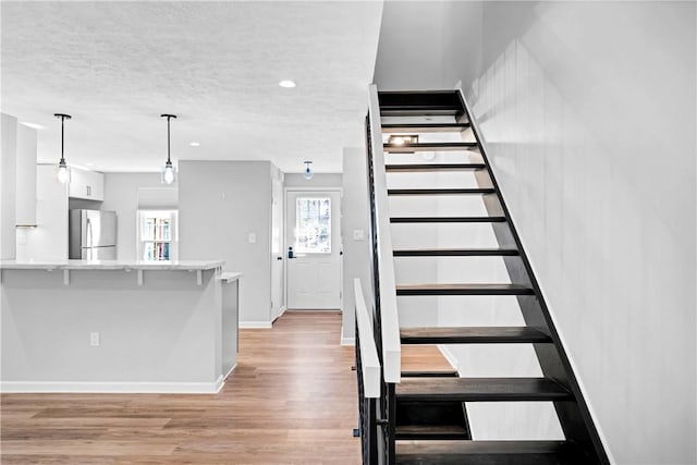 613 Newton Sq, Moon/Crescent Twp, PA 15108 - staircase featuring wood finished floors, a textured ceiling, and recessed lighting