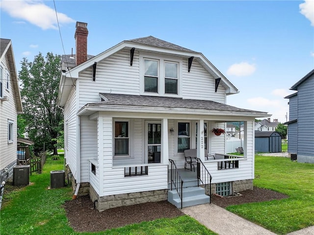 222 S 8th St, West Newton, PA 15089 - view of front of house with a porch, a chimney, a front lawn, a shed, and roof with shingles