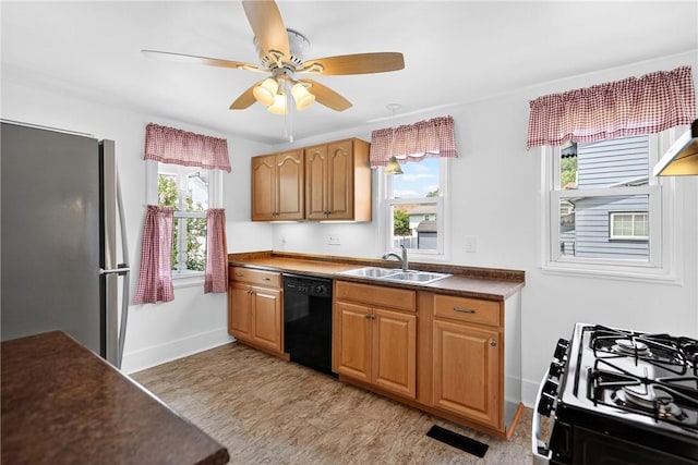 222 S 8th St, West Newton, PA 15089 - kitchen with black dishwasher, freestanding refrigerator, gas stove, dark countertops, and a ceiling fan