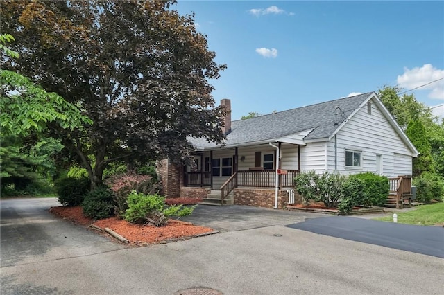 168 Debernardo Ln, Mahoning Twp, PA 16132 - view of front of house with a porch, a shingled roof, a chimney, and asphalt driveway