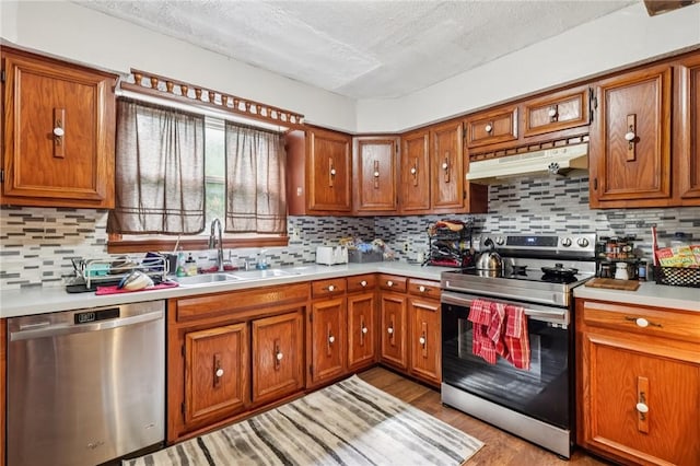 168 Debernardo Ln, Mahoning Twp, PA 16132 - kitchen featuring appliances with stainless steel finishes, under cabinet range hood, light countertops, brown cabinetry, and a textured ceiling