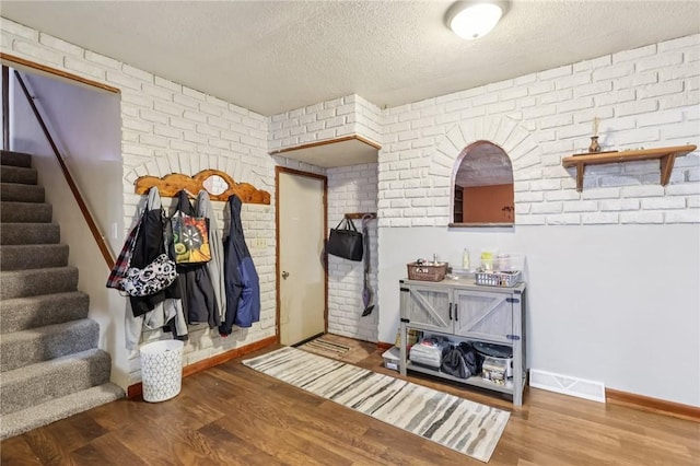 168 Debernardo Ln, Mahoning Twp, PA 16132 - foyer with brick wall, wood finished floors, stairway, and a textured ceiling