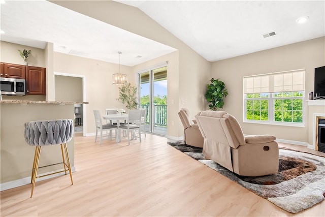 219 Stockton Rdg, Cranberry Twp, PA 16066 - living area featuring light wood finished floors, a chandelier, a glass covered fireplace, recessed lighting, and lofted ceiling
