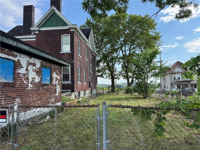 2019 Jenny Lind St, Mckeesport, PA 15132 - view of side of property with a chimney, brick siding, and a gate
