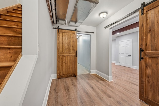 416 Willow Ct, Allegheny Twp, PA 15613 - hall featuring a barn door, wood finished floors, and stairway