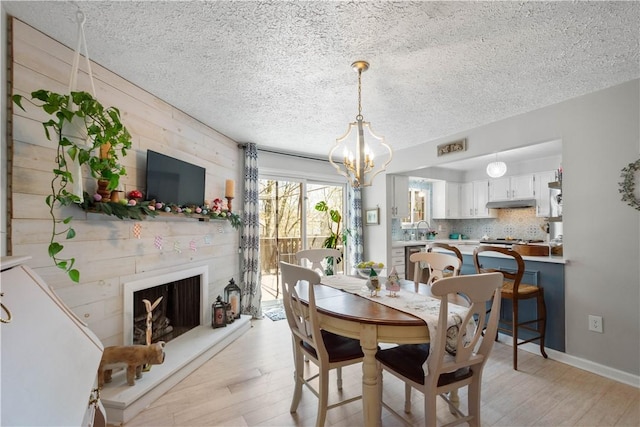 507 Sewickley Heights Dr, Aleppo, PA 15143 - dining room with a textured ceiling, light wood-style floors, a chandelier, and a large fireplace