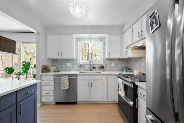 507 Sewickley Heights Dr, Aleppo, PA 15143 - kitchen featuring appliances with stainless steel finishes, under cabinet range hood, white cabinets, light countertops, and plenty of natural light