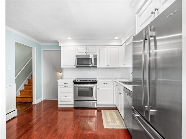 119 Abington Dr, Mt Lebanon, PA 15216 - kitchen featuring stainless steel appliances, baseboard heating, dark wood-style flooring, ornamental molding, and white cabinetry