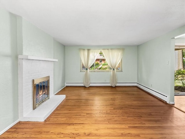 119 Abington Dr, Mt Lebanon, PA 15216 - unfurnished living room featuring a brick fireplace, wood finished floors, and a baseboard radiator