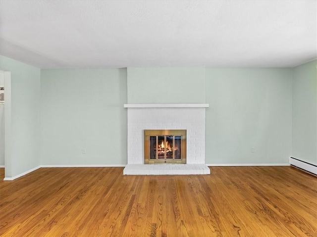 119 Abington Dr, Mt Lebanon, PA 15216 - unfurnished living room with wood finished floors, a brick fireplace, and baseboard heating